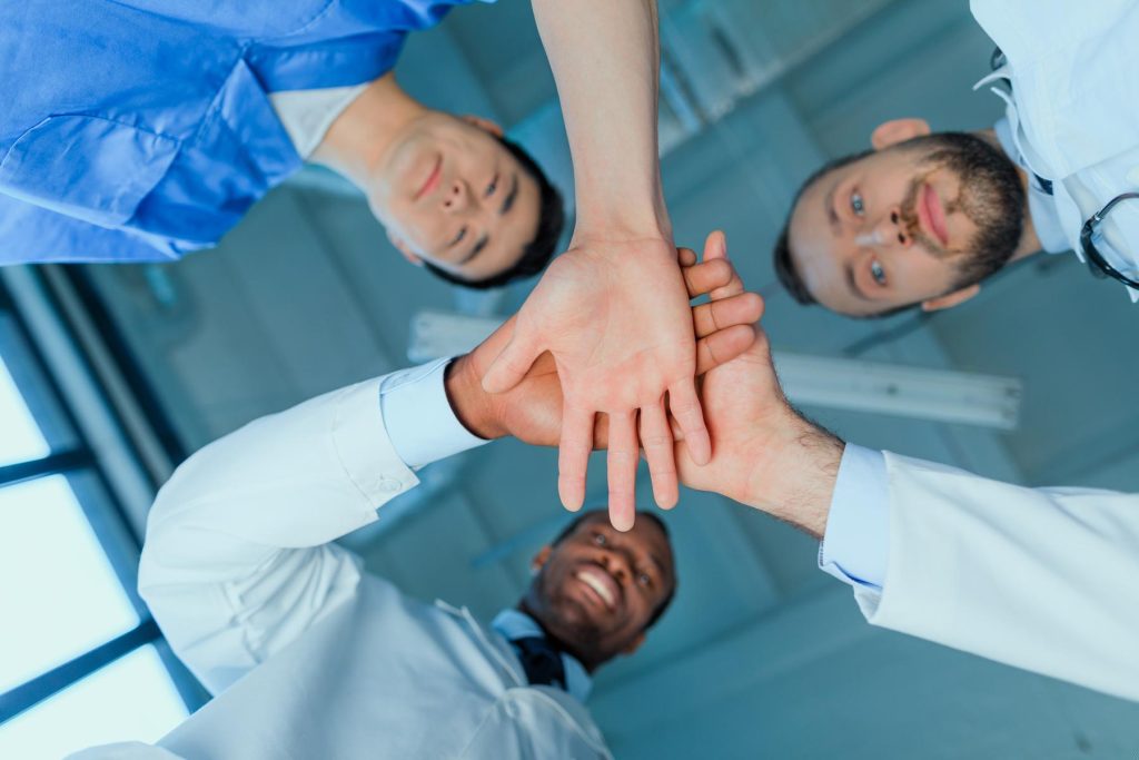 bottom-view-of-multiracial-group-of-doctors-holdin-2024-11-18-05-36-57-utc